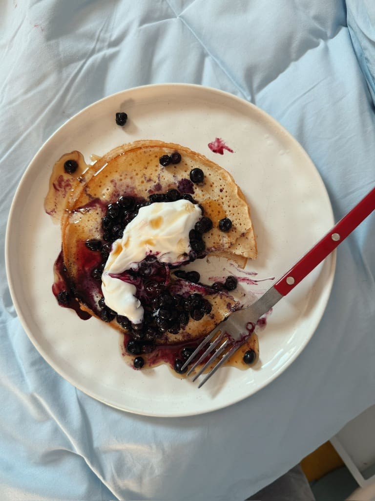 Registered dietitian Claire Rifkin sitting at her desk with a warm neutral background, writing about emotional eating during the holidays and how stress affects appetite and cravings.