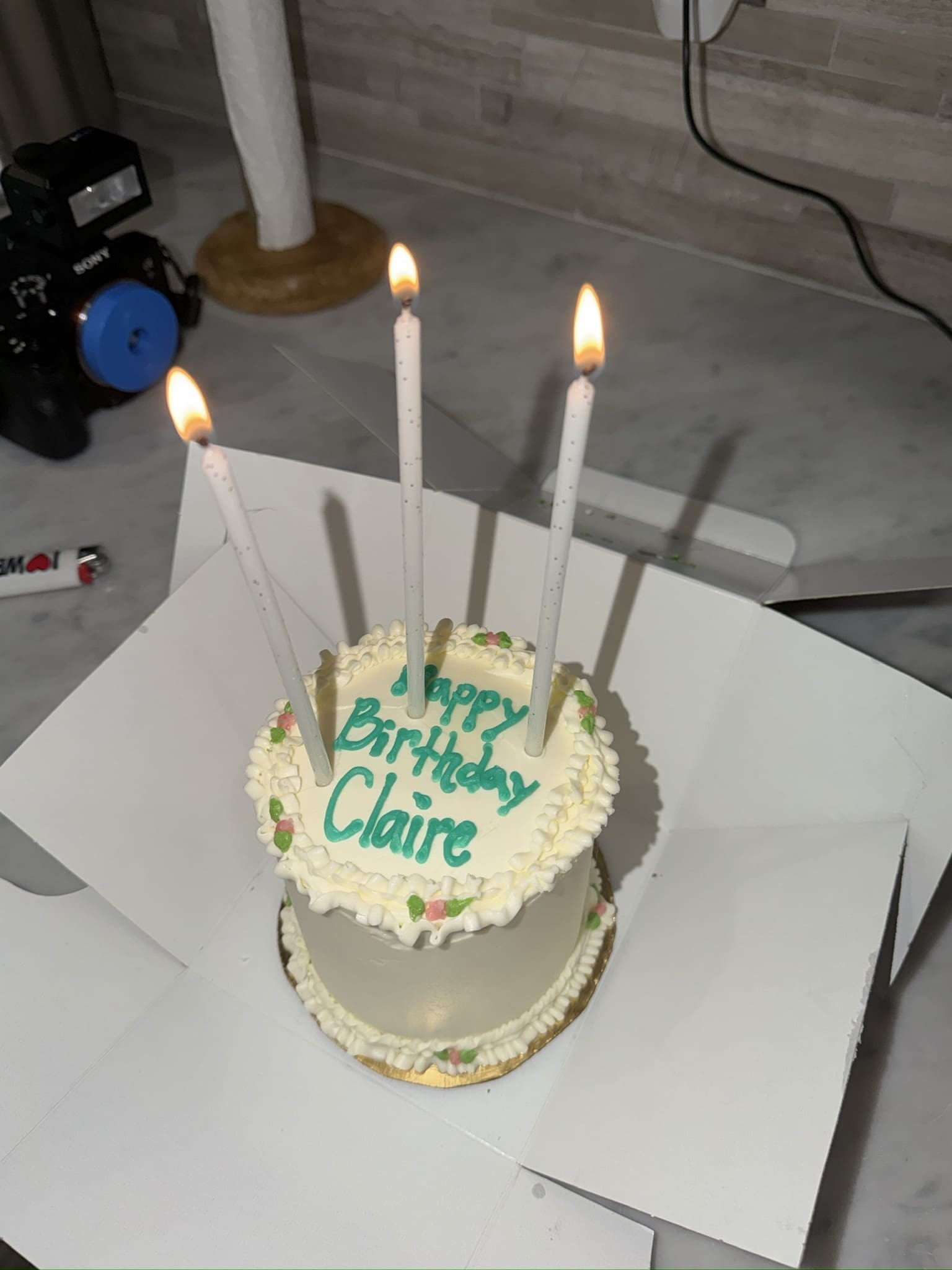 Birthday cake with lit candles that says Happy Birthday Claire, used for a personal blog post about aging in your 30s and making peace with your body.