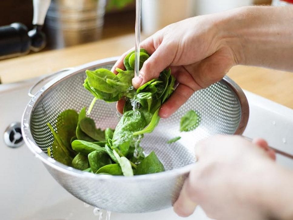 Washing leafy greens under running water